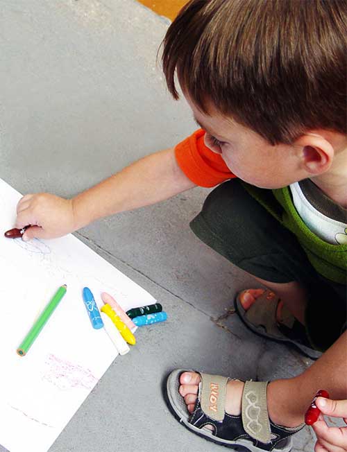 A kid drawing with color pencil